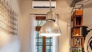 A dining area with a long wooden table, clear chairs, and a hanging pendant light. - MOT Rentals + Dorrego House - Pool in Palermo Hollywood (Buenos Aires)