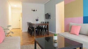 Een moderne woonkamer met een bank, een salontafel en een eethoek met stoelen en een tafel.