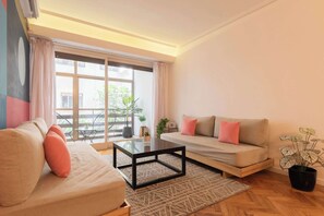 A living room with a sofa, a coffee table, and a potted plant. - Mot Rentals + Junin Recoleta Mall 4 Bd (Buenos Aires)