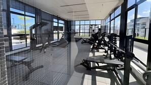 A gym with exercise equipment and large windows. - Move Oásis Tambaú (Joao Pessoa)