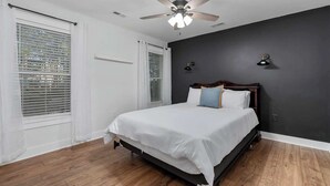A bedroom with a bed, a ceiling fan, and a window with blinds. - Charming home near Clemson, SC! (Central)