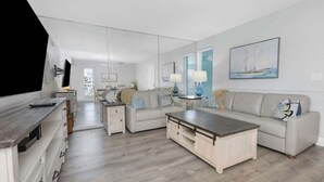 Ein modernes Wohnzimmer mit einer Couch, einem Couchtisch und einer TV-Konsole.