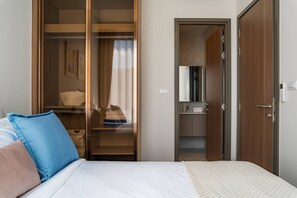 A bedroom with a bed, a wardrobe, and a bathroom. - Cozy 2br Apartment Pool View- canvas- bangtao area (Choeng Thale)