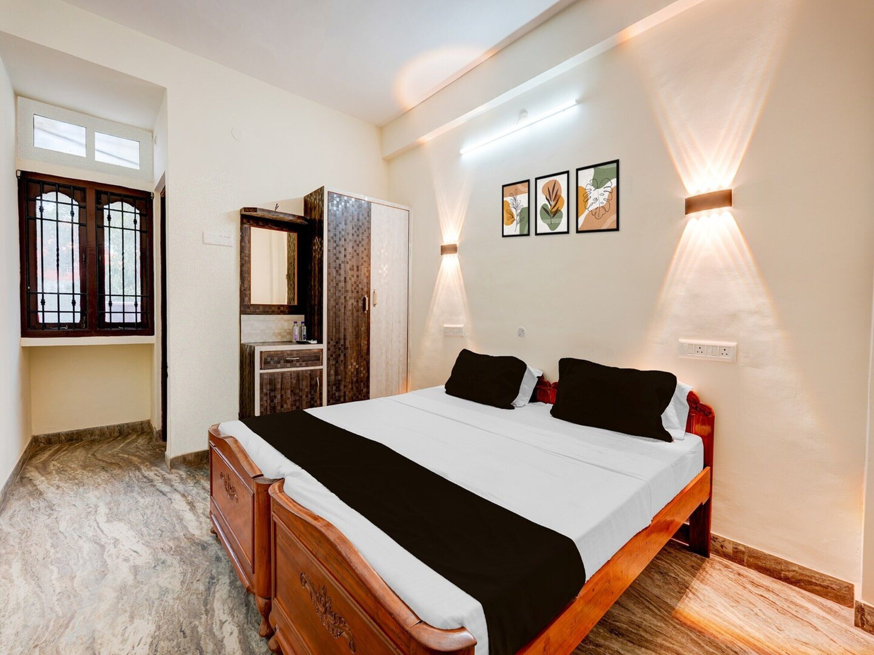 Ein Schlafzimmer mit einem großen Bett, einem Schminktisch, einem Frisierkommode und Wandleuchten.