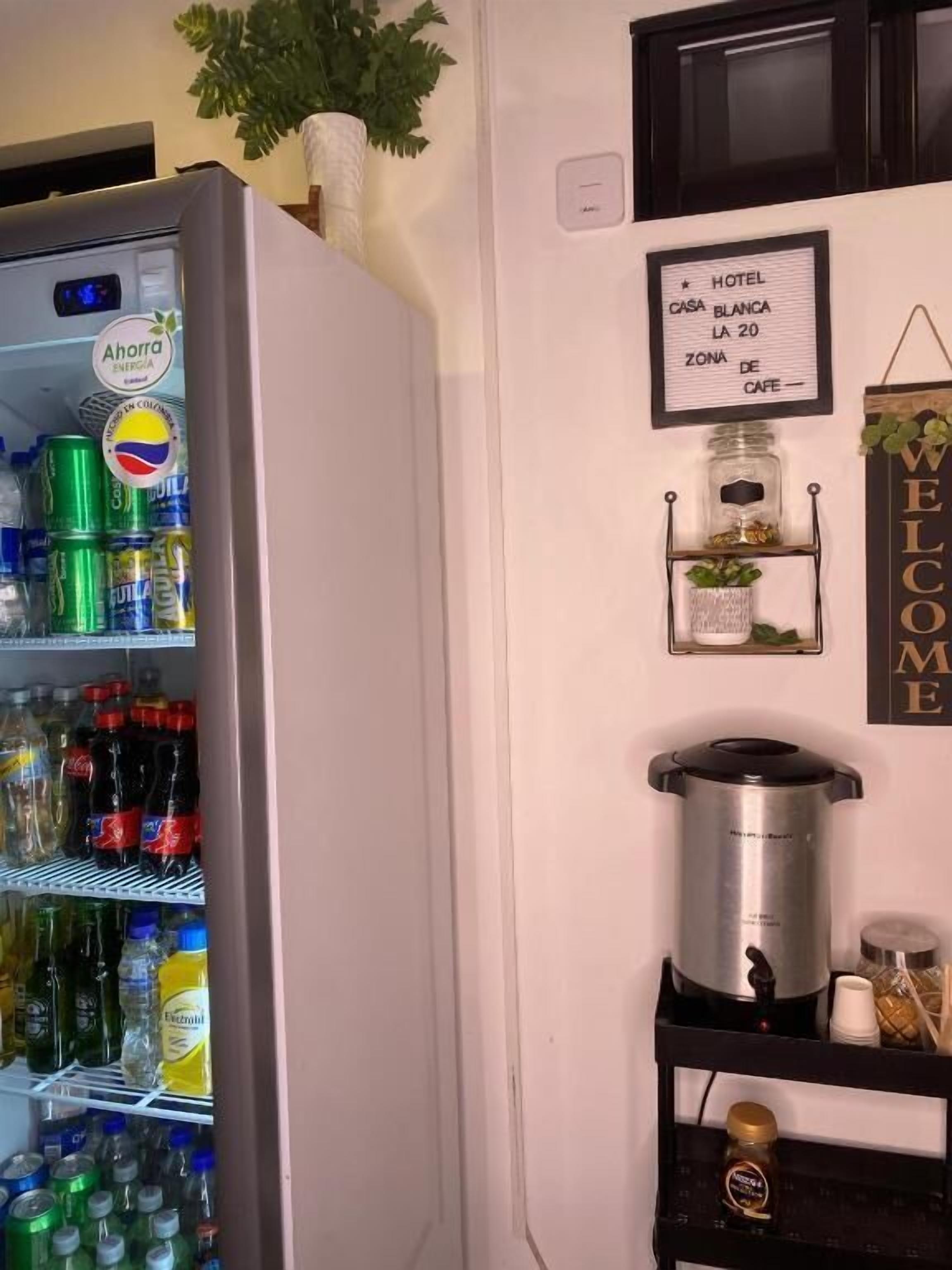 A refrigerator stocked with beverages, a sign indicating a hotel named 'Casa Blanca,' and a welcome sign.