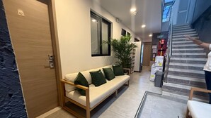 Un interior moderno con un sofá, una escalera y una puerta con la etiqueta '02'.