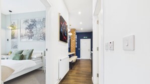 Et hotelværelse med en seng, et skrivebord og udsigt til gangen.