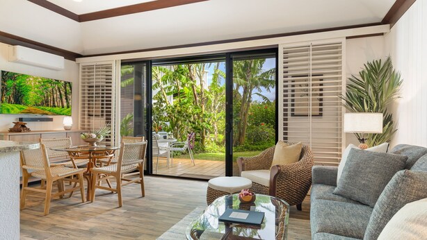 A spacious living area with a dining set, a sofa, and a coffee table. - Kiahuna #44 • A/C • REMODELED & UPDATED Ground-Floor End Unit • 2 Min to Beach (Koloa)