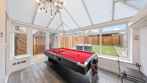 Een pooltafel in een ruimte met grote ramen en een hoge plafond.