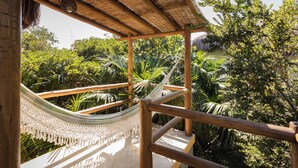 A hammock under a wooden pergola with a view of lush greenery. - Pousada Colmeia (Santa Cruz Cabrália)