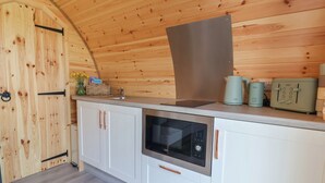 Una cocina compacta equipada con microondas, hervidor y tostadora.