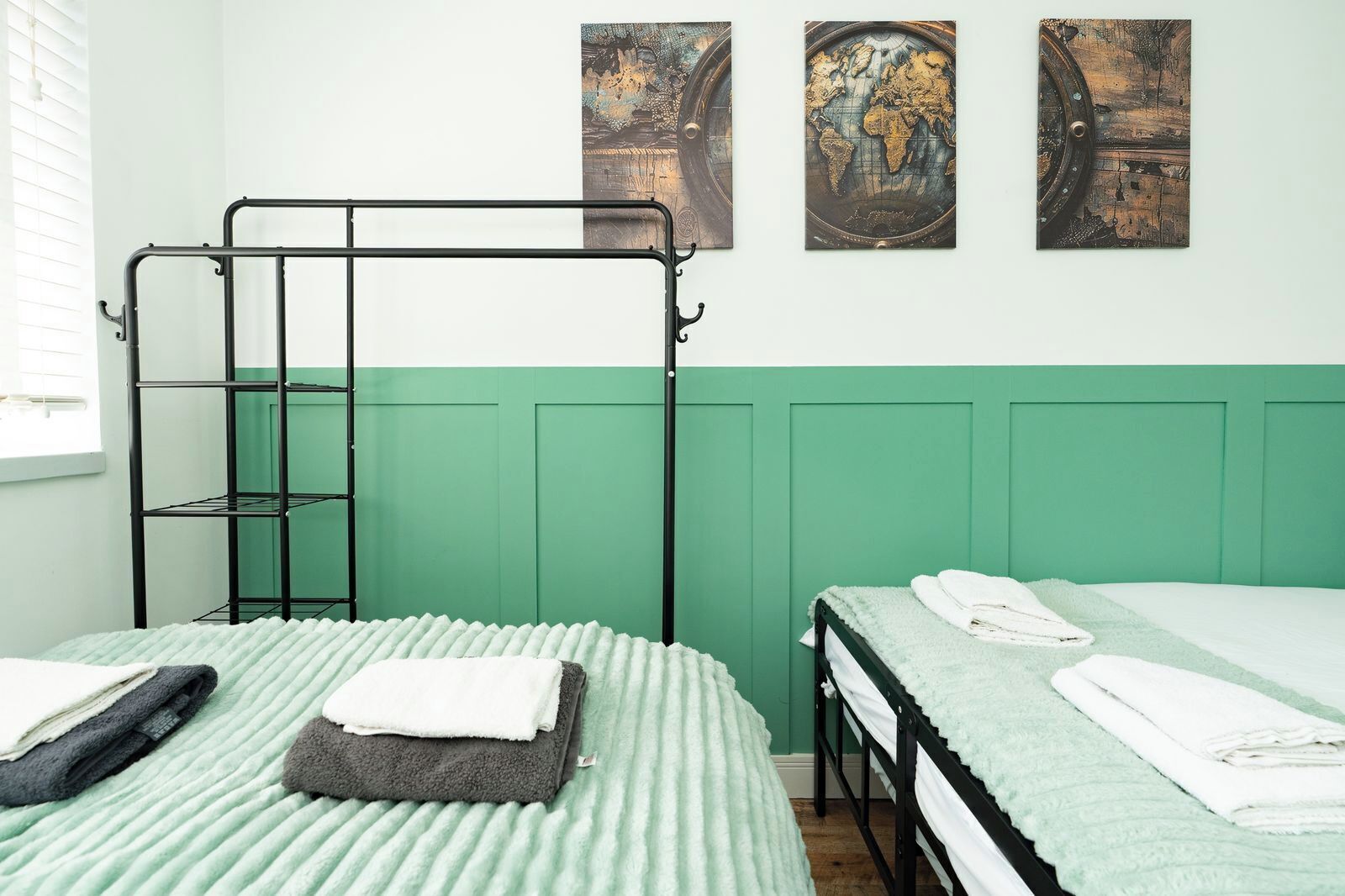 A dormitory room with bunk beds, a ladder, and a green wall.