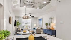 A modern kitchen with a central island, built-in oven, and a dining area with a round table. - The Cove:2 bdrm, 4 minute walk to A&M (College Station)