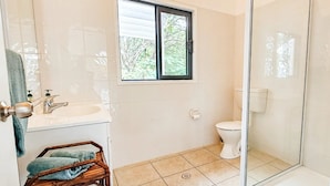 A bathroom with a toilet, sink, and shower area. - Toreaiva 91 Beachfront Studio - Upper (Arorangi)