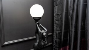 A wall-mounted light fixture with a round bulb, a wall with a decorative molding, and a curtain. - Lovely 1-bedroom studio with AC in Phoenix (Phoenix)