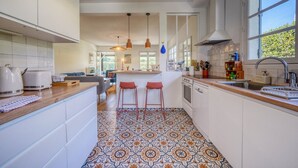 Una cucina moderna con mobili bianchi, pavimento in piastrelle decorate e un'ampia finestra.