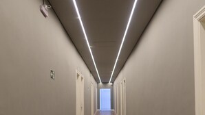 A long, narrow hallway with wooden flooring and light-colored walls.