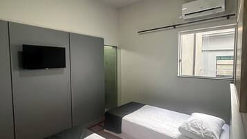 Quarto com duas camas, televisão de tela plana, ar-condicionado e janela com vista.