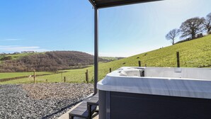 Ein Whirlpool unter einem Überdachung mit Blick auf eine grüne Landschaft.