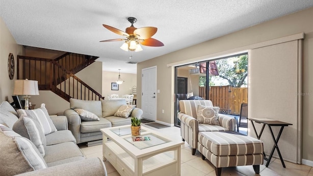 A living room with a sofa, ottoman, coffee table, and a ceiling fan. - Beautiful Townhome/Fully Furnished in the heart of Palm Harbor. (Palm Harbor)