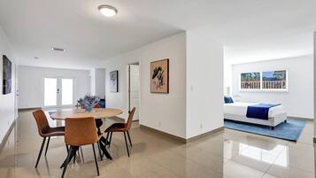 Un espace de vie moderne comprenant un coin repas, une chambre et une salle de bain.