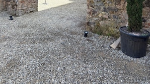 An ancient stone archway, a potted evergreen tree, and a gravel courtyard. - Dimora di Duen (Villa San Giovanni)