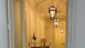 A hallway with a checkered floor, a wooden dresser, and two hanging lanterns. - Dimora di Duen (Villa San Giovanni)