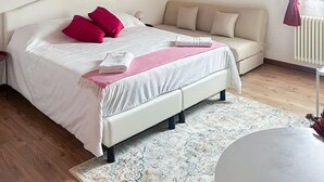 Une chambre à coucher avec un lit, un canapé, un lustre et un radiateur.