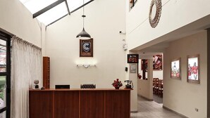 A reception area with a wooden counter, a framed logo, a pendant light, and framed pictures on the walls.