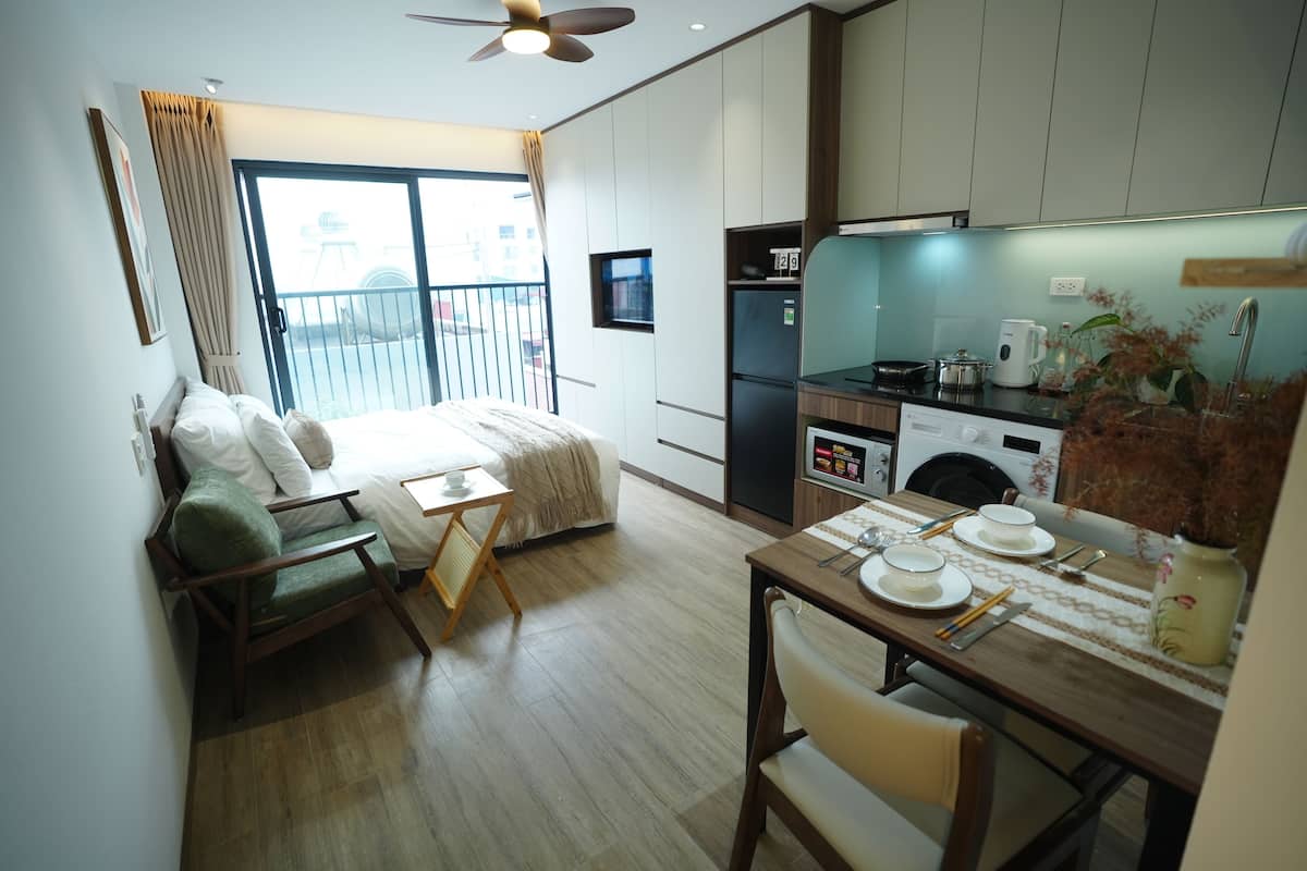 Une chambre d’hôtel moderne dotée d’un balcon, d’un coin repas et d’une kitchenette.