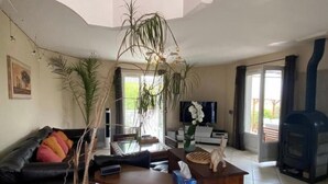 Un salon avec un canapé, une table basse, un téléviseur et une cheminée.