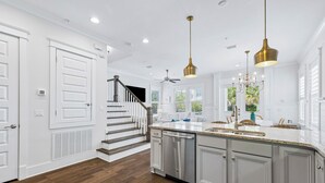 A modern kitchen with a central island, stainless steel appliances, and pendant lighting. - Community Pool and Hot Tub Access | LSV (Santa Rosa Beach)