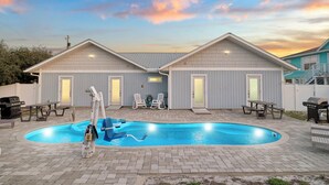 Propiedad residencial con piscina, dos viviendas adosadas y mobiliario exterior.