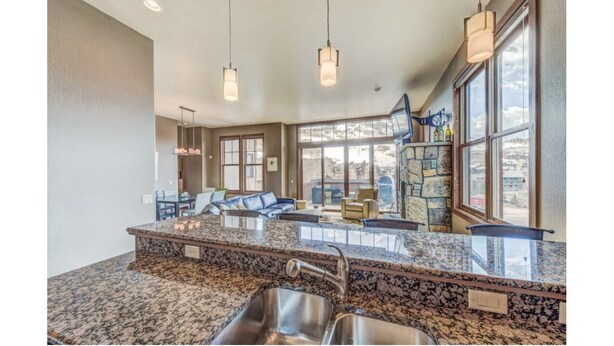 A spacious kitchen with granite countertops, stainless steel sinks, and pendant lighting. - LUXURY 4-BED 5-BATH VILLA ACROSS FROM Mt CB BASE, SLEEPS 12 (Crested Butte)