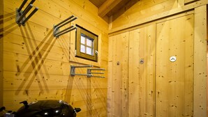 A wooden interior with a grill, a window, and a door with a hanger symbol.