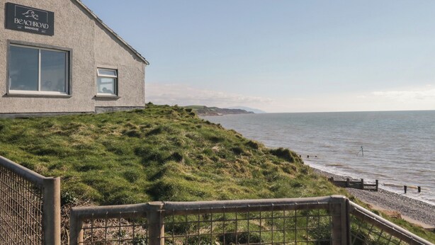 A building with a sign reading 'Beachcroft Bakehouse' overlooking a coastal area. - The Swift (St Bees)