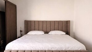A bedroom with a large bed, wooden flooring, and a wardrobe. - Totalmente equipado, Zona Providencia, Apartment (Guadalajara)
