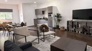 A modern living room with a sofa, coffee table, and a TV. - Totalmente equipado, Zona Providencia, Apartment (Guadalajara)