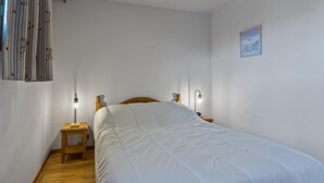 Una camera da letto con un letto grande, due comodini, un tavolino e una lampada a parete, oltre a un quadro incorniciato.