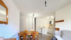 Un espace de vie compact comprenant un coin repas, une kitchenette et un canapé.