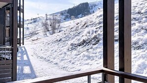 Un paysage enneigé avec un balcon en bois et un bâtiment en arrière-plan.