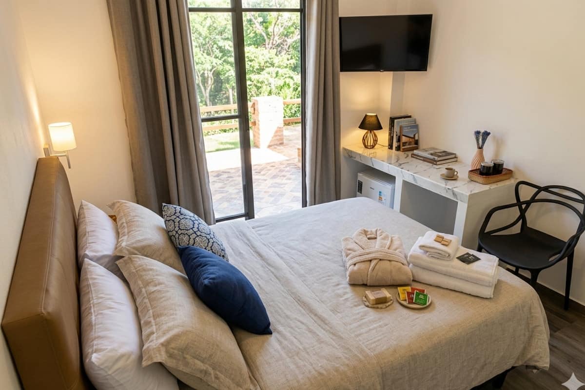Une chambre d’hôtel avec un lit, un bureau avec une télévision, une chaise et une vue sur l’extérieur.