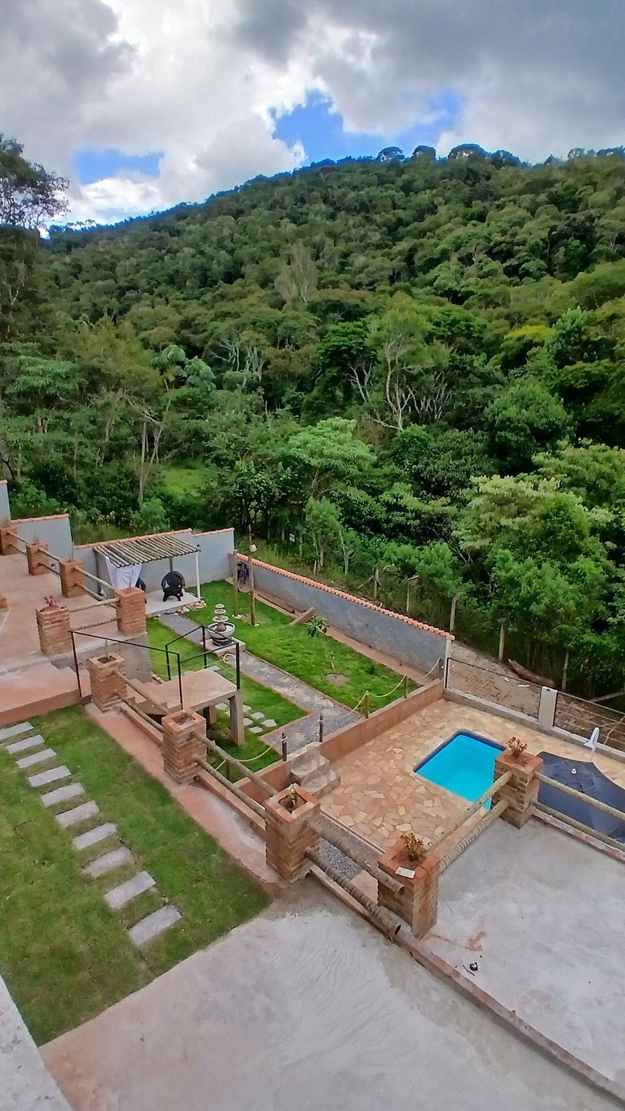 Un área de piscina en la azotea con vistas a un promontorio boscoso.