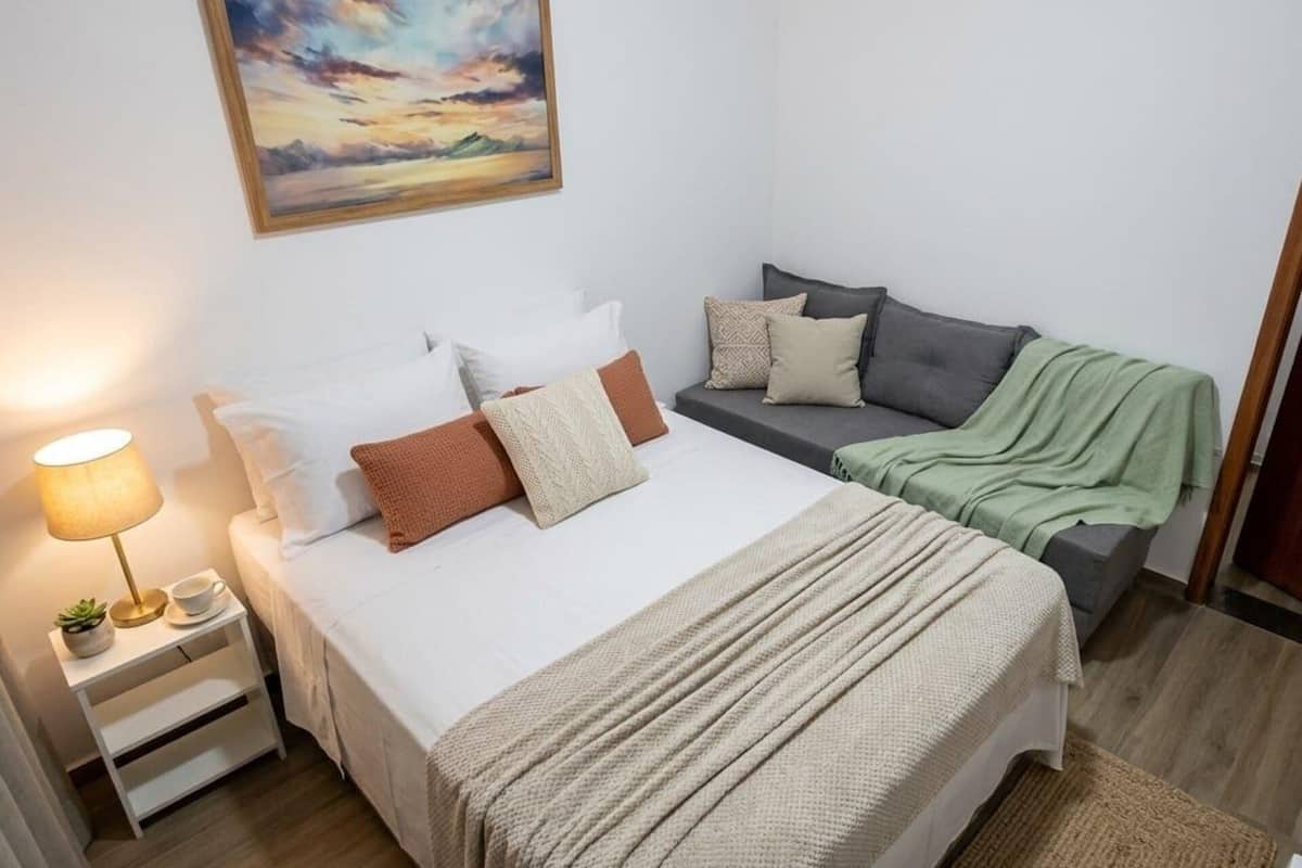 Une chambre à coucher avec un lit, une table de chevet, une lampe et un tableau au mur.
