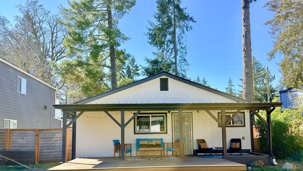 A single-story house with a covered porch, a front door, and a small deck area. - NEW! Peaceful Bungalow • Close to Lightrail • Yard (Seattle)