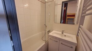 Ein Badezimmer mit Badewanne, Waschbecken und einer Duschkabine aus Glas.
