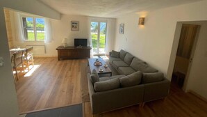 A spacious living area with a sofa, a dining table with chairs, a TV, and a fireplace. - 100m from ski slopes, Ground floor, tv, 80m², Pra Loup (Pra Loup)