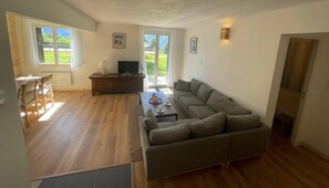 A spacious living area with a sofa, a dining table with chairs, a TV, and a fireplace. - Ground floor, tv, 80m², Pra Loup (Pra Loup)