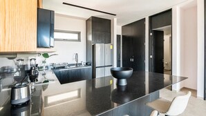 Eine moderne Küche mit einer zentralen Kochinsel, Edelstahlgeräten und einem minimalistischen Design.