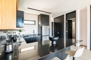 Eine moderne Küche mit einer zentralen Kochinsel, Edelstahlgeräten und einem minimalistischen Design.